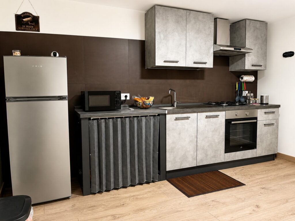 Cucina attrezzata di Aghena con frigorifero, forno, piano cottura e microonde